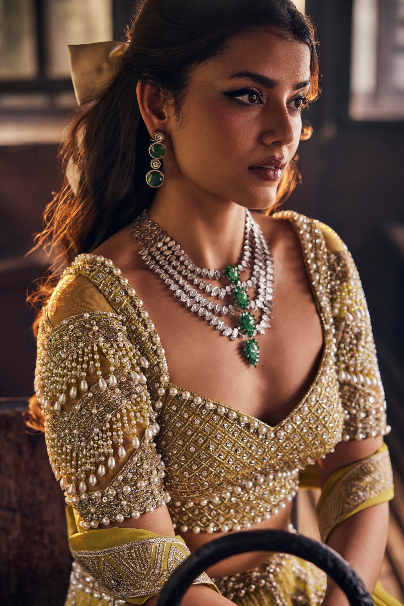 A woman wearing an ornate embellished traditional outfit with extensive pearl and bead work. Perfect outfit for weddings, sangeet, mehendis, and other festivities.